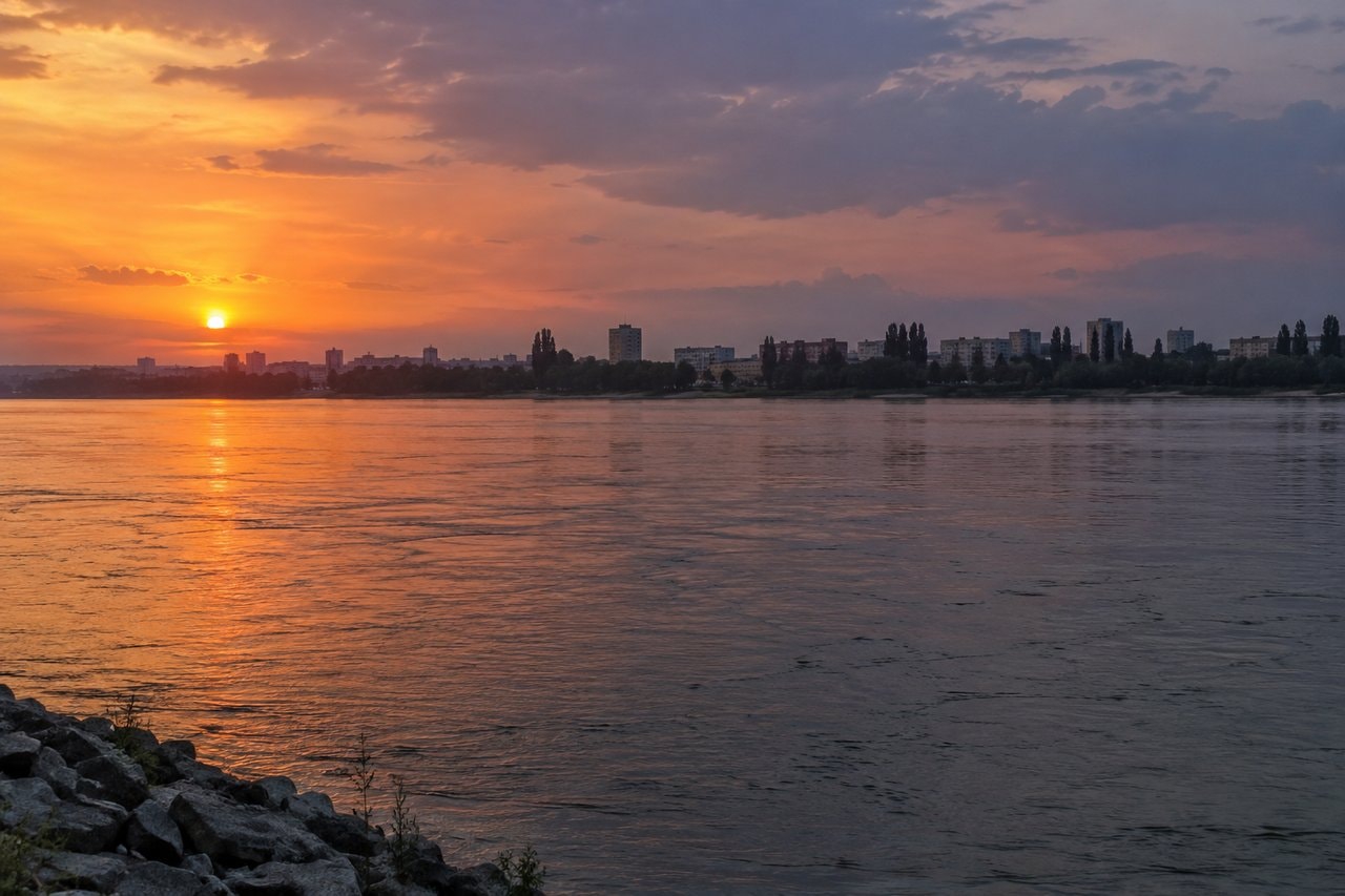 Sunset light across a broad river and distant skyline